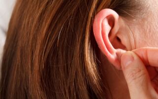 hands inspecting earlobe