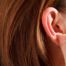 hands inspecting earlobe
